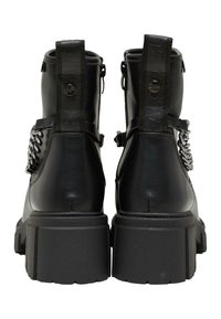 Botas de tobillo de cuero negro con suela gruesa, que cuentan con un cierre de cremallera, asas en forma de bucle y un detalle decorativo de cadena.