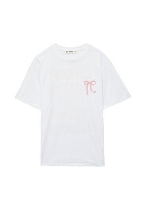 T-shirt bianca a maniche corte con collo rotondo, con una piccola grafica di fiocco rosa sul lato sinistro del petto.