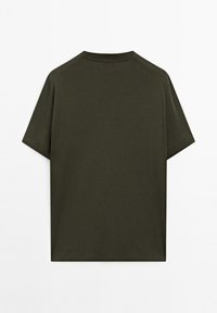 Tmavě olivově zelené tričko s krátkým rukávem vyrobené z bavlny. Má kulatý výstřih a jednoduchý, čistý design bez vzorů nebo accentů.