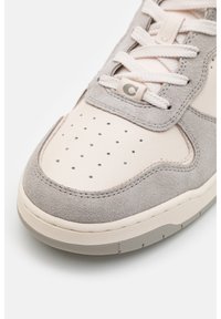 Sneaker in suede grigio e pelle testurizzata con tomaia perforata, rifiniture color crema, lacci piatti e suola in gomma. Presenta un logo sulla linguetta.