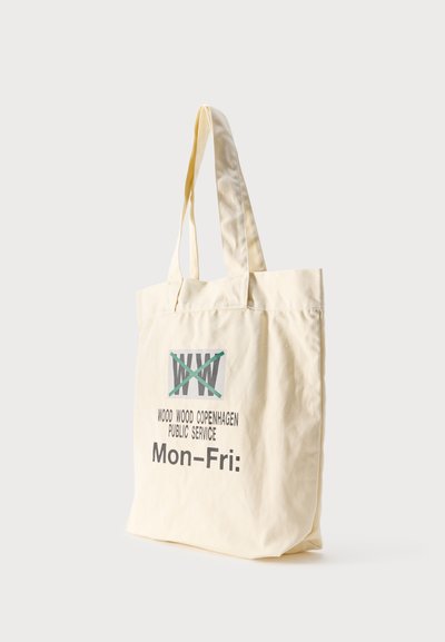 Geantă tote bej cu mânere lungi, având logo și textul „WOOD WOOD COPENHAGEN PUBLIC SERVICE Mon-Fri:” imprimat în negru și verde.
