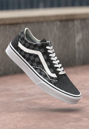 Black and gray checkerboard pattern sneaker with white laces and side stripe. Features white rubber sole and textured fabric upper.