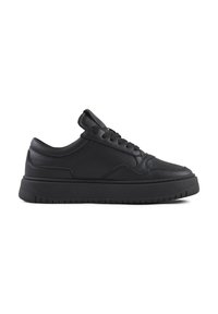 Zapatilla de piel negra con punta redondeada, diseño de cordones, cuello acolchado y suela de goma texturizada con ranuras horizontales.