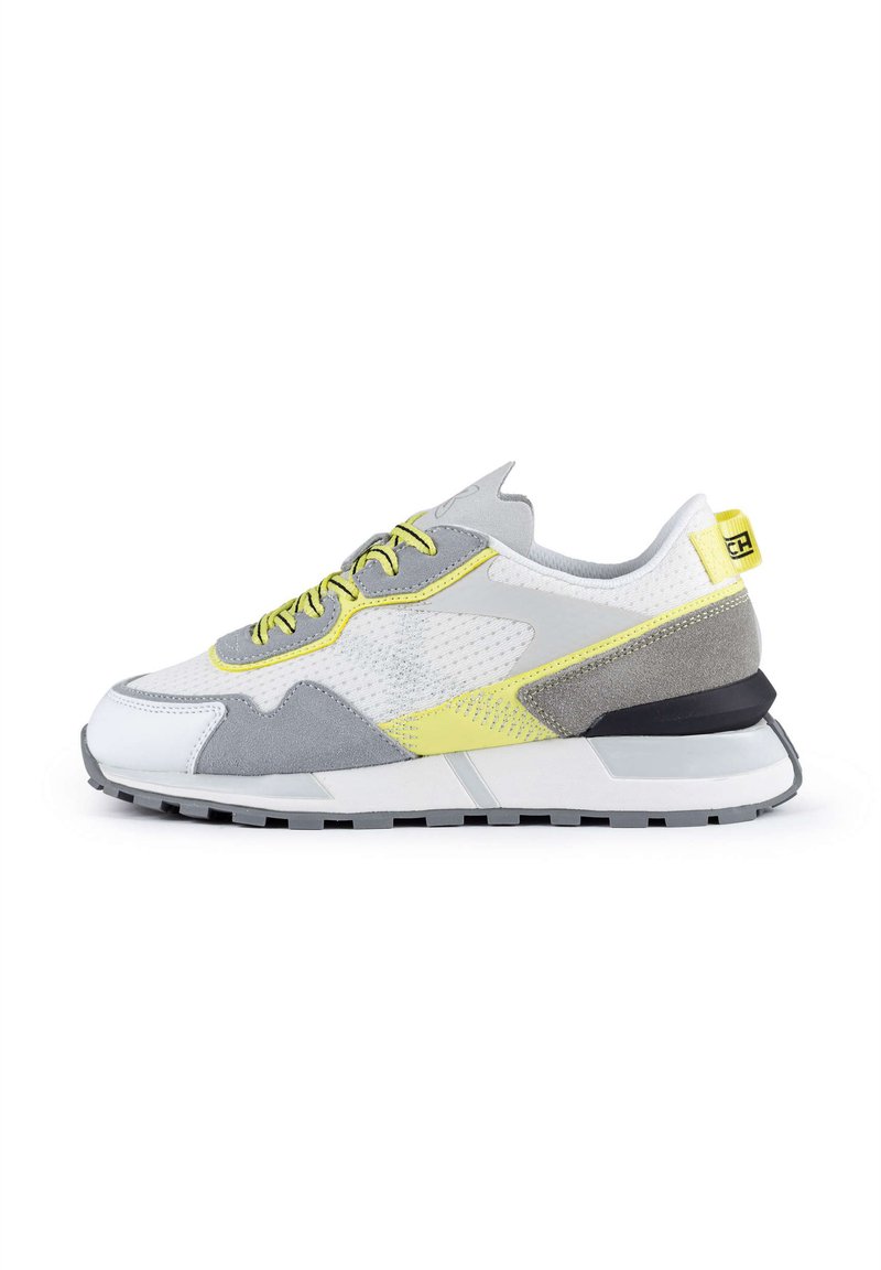 Sneakers in white, grey, and yellow with a mesh upper, suede accents, and a chunky black sole. Features textured elements and contrasting laces.
