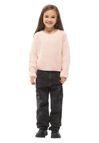 Jasnoróżowy, dzianinowy sweter z długimi rękawami, zestawiony z czarnymi spodniami cargo z bocznymi kieszeniami i czarnymi butami.