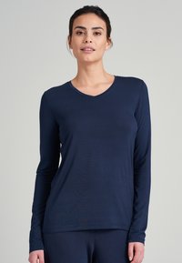 Marinblå långärmad t-shirt med V-ringning, tillverkad av mjukt tyg, med åtsittande ärmar och en något avslappnad passform.