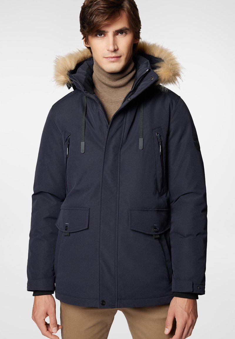 Granatowa ocieplana parka z futrzanym kapturem, z zamkami błyskawicznymi i kieszeniami na klapki, z regulowanym ściągaczem, o gładkiej powierzchni i pikowanej fakturze.