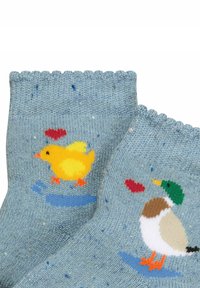 Blaue Socken mit einem gepunkteten Muster. Auf den Seiten befinden sich Designs von einem gelben Küken und einer Ente, jeweils mit einem roten Herzen, in kontrastierenden Farben.