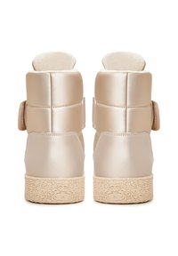 Bézs színű bokacsizma sima selyemfényű felülettel, párnázott felső résszel, állítható pánttal és textúrált gumitalppal.