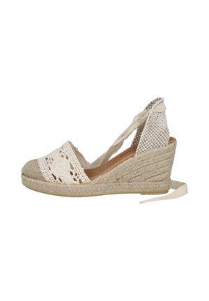 Sandalia cuña espadrille beige tejida con atadura en el tobillo, parte delantera de ganchillo y suela plataforma de yute trenzado.