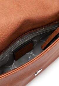 Bolso de cuero marrón con un exterior texturizado. El interior cuenta con un forro gris con patrones circulares y compartimentos con cremallera.
