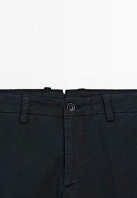 Chino blu scuro con gamba dritta, passanti per cintura, tasche laterali, zip anteriore e chiusura con un solo bottone. Materiale di cotone liscio.