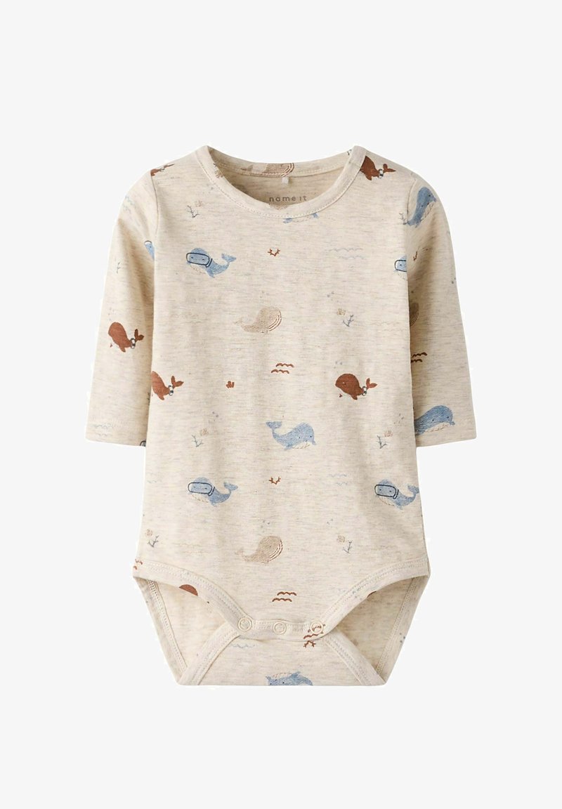 Body beige pour bébé à manches longues, orné de motifs de baleines bleues et marron, avec des boutons-pression à l'entrejambe pour la fermeture.