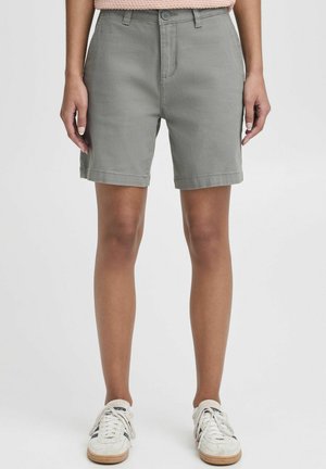 Shorts en mélange de coton gris avec une coupe droite, bouton de fermeture, poches latérales et ourlets retroussés. Associés à des baskets légères.