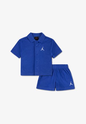 Blauw setje met kort mouw overhemd en bijpassende korte broek met witte Jumpman-logo's op de borst en het been.