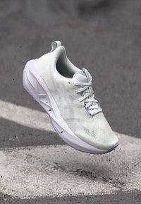 Λευκό αθλητικό παπούτσι με υφασμάτινη άνω επιφάνεια, κλείσιμο με κορδόνια και μαλακή σόλα. Σχεδιασμένο για άνεση με μια ελαφριά εμφάνιση.