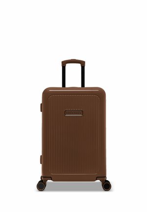 Brown hard-shell suitcase with ridged texture, black telescopic handle, and four wheels for mobility. Logo visible on the front.
