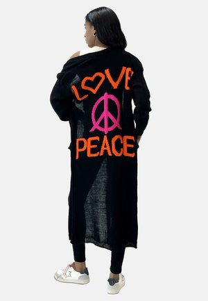 Cardigan lungo nero con testo luminoso arancione e rosa che dice "AMORE" e "PACE", caratterizzato da una trama a maglia allentata e design aperto.