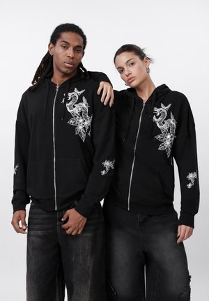 Crna zip-up hoodie od pamuka, s bijelim grafičkim otiscima morskih konjica i cvijeća na prednjoj strani i rukavima. Ležeran kroj.