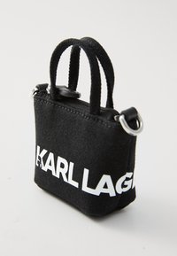 Sac à main en toile noire avec des poignées doubles, fermeture éclair et logo blanc "KARL LAGERFELD". Caractéristiques de quincaillerie argentée et forme rectangulaire compacte.