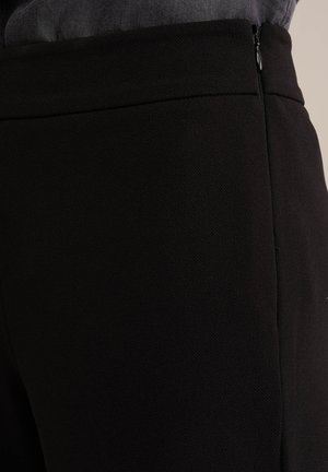 Pantaloni neri su misura con una trama liscia, caratterizzati da un motivo sottile, chiusura laterale con zip e un design aderente.