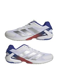 Scarpe sportive bianche con strisce argentate, dettagli blu e tacco rosso. Presentano una tomaia testurizzata e un design esclusivo della suola geometrica.