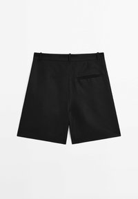 Shorts noirs sur mesure avec passants de ceinture et une unique poche passepoilée au dos, posés à plat sur un fond blanc.