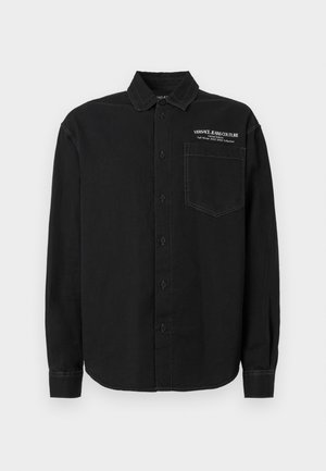 Must have musta pika varrukaga särk pehmest kangast, millel on terav krae, nööpide kinnitamine ja valge logo detailidega tasku.