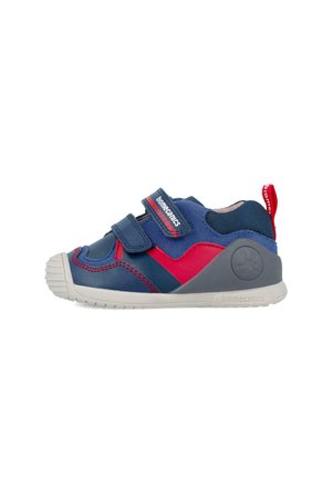 Zapatilla azul y roja con correas de velcro, punta de goma, parte superior de malla texturizada y un acento en gris en el talón con un logotipo.