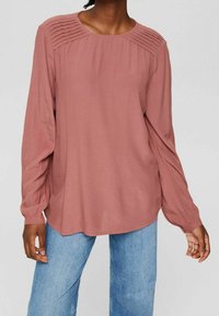 Langärmlige Bluse in staubigem Rosa, mit gefälteltem Detail an den Schultern, rundem Ausschnitt und einem fließenden, lockeren Schnitt.