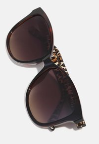 Ochelari de soare cu lentile supradimensionate negre, rame transparente de culoare maronie și accente cu imprimeu animal pe tempuri. Textură netedă și design îndrăzneț.