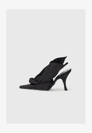 Chaussure à talon aiguille noire avec un bout pointu, présentant un doux superposé en tissu drapé et un talon mince et courbé.