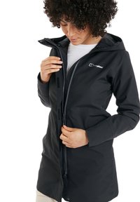 Schwarze wasserdichte Jacke mit Reißverschluss, verstellbarem Kapuzenkragen und Klettverschlussärmeln, mit einem kleinen Logo auf der Brust. Glatte Textur.