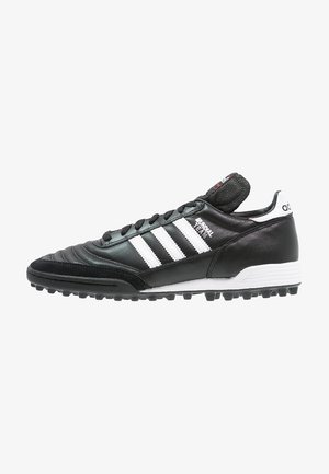 Schwarzer Adidas Mundial Team Fußballschuh mit weißen Streifen, schwarzen Schnürsenkeln, strukturierter Sohle und Branding auf Zunge und Fersenlasche.