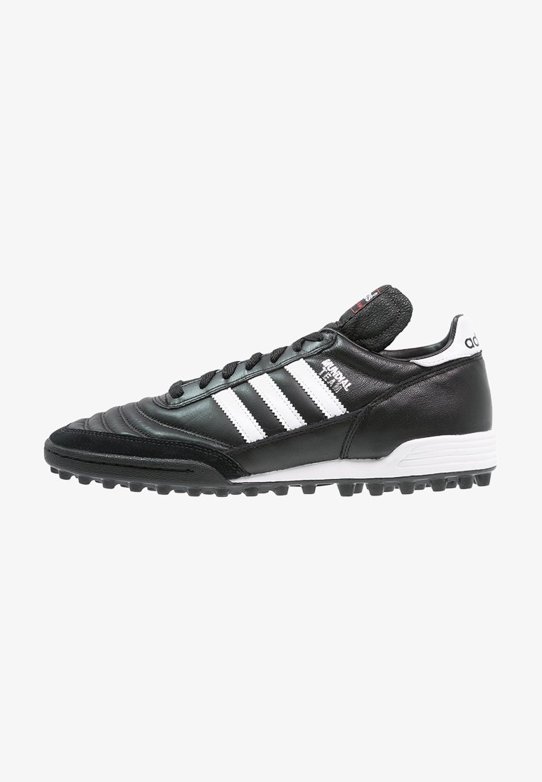 Chaussure de football Adidas Mundial Team noire avec des bandes blanches, des lacets noirs, une semelle texturée et un marquage sur la languette et la languette du talon.