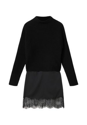 Sort langærmet ribbet sweater kombineret med sort satinkjol med blonder ved kanten.