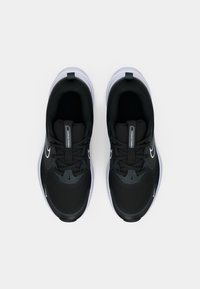 Pair of black and white Nike Cosmic Runner sneakers viewed from above on a plain white background.