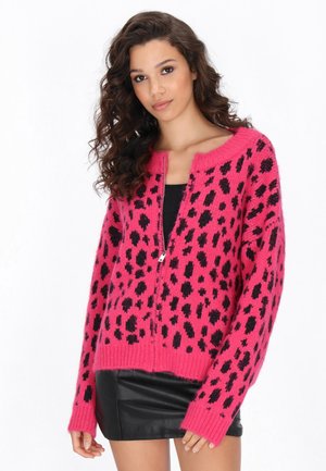 Cardigan rosa a maglia con macchie leopardate nere, dotato di scollatura rotonda e chiusura con zip. Tessuto morbido e vestibilità comoda con maniche lunghe.