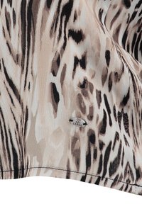 Textil mit einem beigen und braunen Tiermuster und glatter Textur. Enthält ein kleines silbernes Etikett mit dem Text "LARGO".