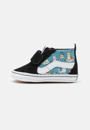Chaussure pour tout-petit noire et bleue avec fermeture Velcro, semelle blanche et motif lama et cactus sur la partie latérale en tissu bleu.