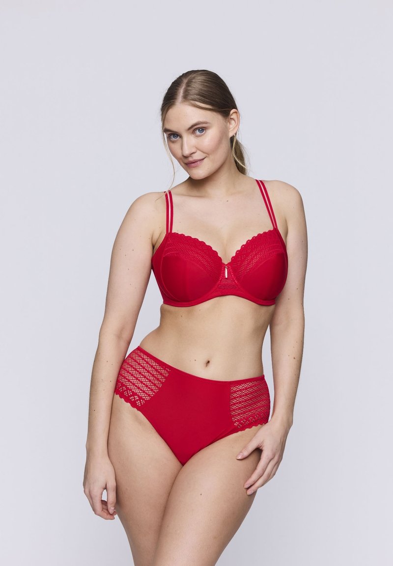 Conjunto de lencería roja que presenta un sujetador con bordes de encaje y varillas, acompañado de unas braguitas de talle alto con detalles de encaje.