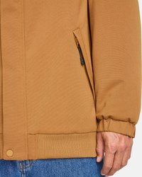 Giacca marrone realizzata in tessuto testurizzato, con una tasca con zip, polsini a coste e orlo elasticizzato. Il design include una chiusura a pulsante.
