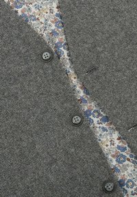 Gray textured fabric with a floral-patterned lining. Features dark buttons and a tailored design. No additional embellishments visible.