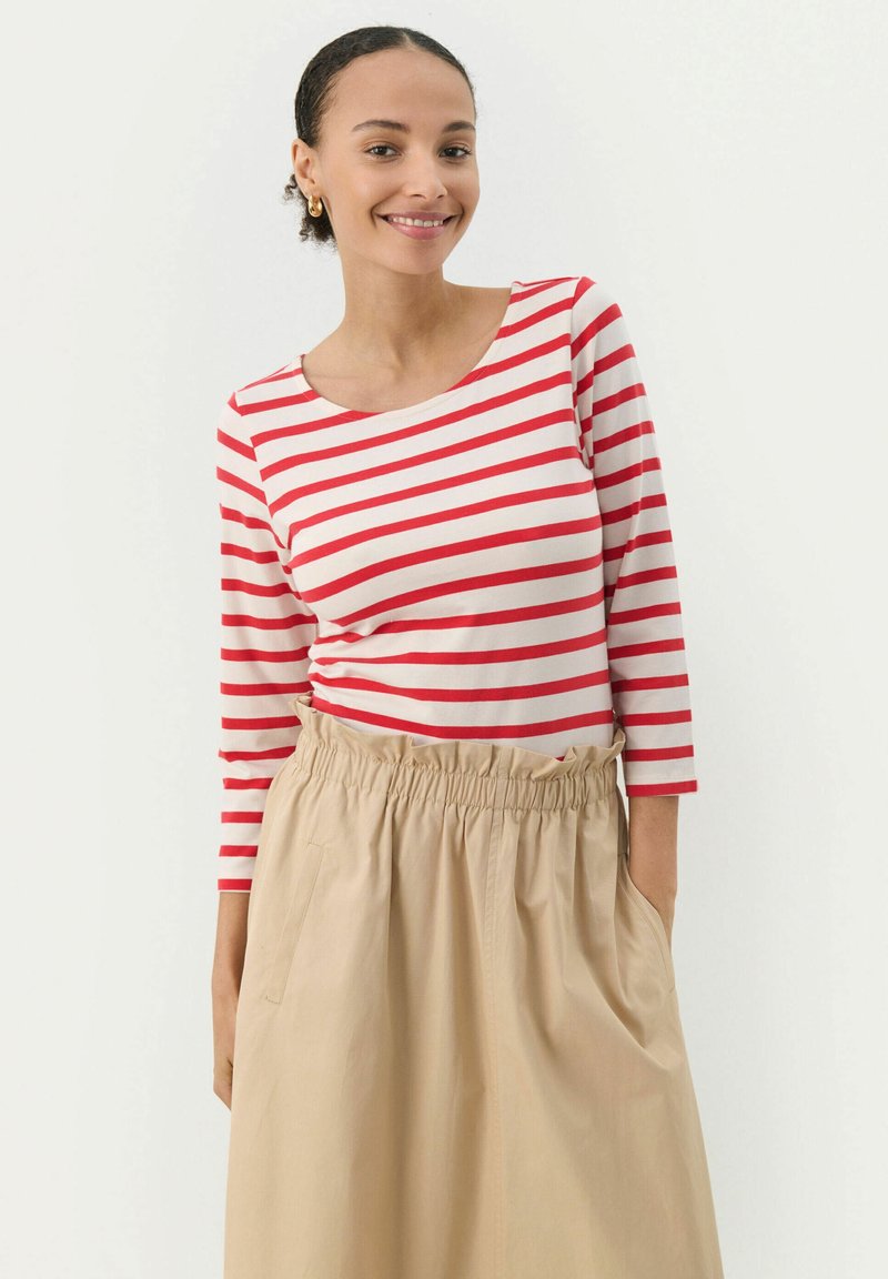 Rød og creme-stribet langærmet skjorte parret med en beige elastisk talje-nederdel, der har sidelommer og en afslappet pasform.