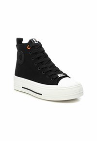 Zapatillas altas negras de lona, con una suela de goma blanca, detalles en negro y un lazo naranja en la lengüeta.