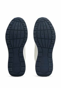 Semelles extérieures en caoutchouc bleu avec des motifs de texture pour une bonne adhérence, présentant un intermédiaire blanc et des détails de marque visibles sur les côtés.