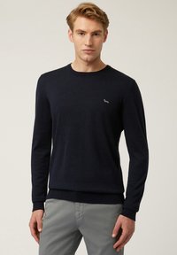 Maglione blu navy a maniche lunghe realizzato in materiale morbido, con scollo a girocollo e un piccolo logo ricamato sul petto.