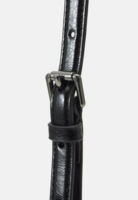 Bracelet en cuir noir avec une finition texturée, des trous ajustables et une boucle en métal argenté à profil plat.
