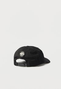 Μαύρο ρυθμιζόμενο καπέλο μπέιζμπολ με στρογγυλή ετικέτα λογότυπου Palladium στο πίσω μέρος, εμφανιζόμενο σε απλό λευκό φόντο.