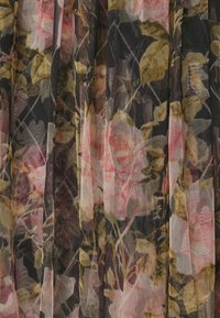 Tissu noir transparent avec un motif floral de roses roses et de feuilles jaune-vert, présenté en plis verticaux.